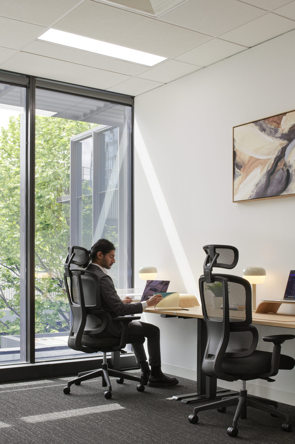 Staff Member Sitting in a Black H2 Ergonomic Medium Back Office Task Chair in at Waterman Moonee Ponds Coworking Centre