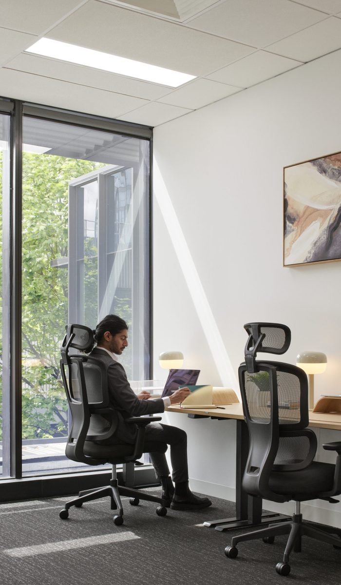 Staff Member Sitting in a Black H2 Ergonomic Medium Back Office Task Chair in at Waterman Moonee Ponds Coworking Centre